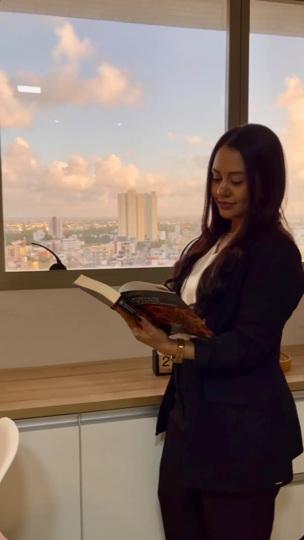Hanna Luara lendo junto à janela do consultório